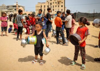 KANAK-KANAK Palestin yang dipindahkan beratur untuk menerima makanan di Rafah, di selatan Gaza, pada 19 Mei lalu. -AFP