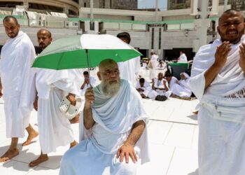 SEORANG jemaah haji memegang payung selepas menunaikan solat di Masjidil Haram di kota suci Mekah.-AFP