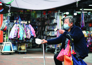 An elderly woman begs for alms in the Kowloon district of Hong Kong on February 27, 2024, a day ahead of the city's annual budget to be announced on February 28. (Photo by Peter PARKS / AFP)