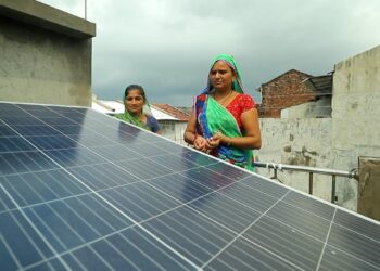 PENDUDUK menunjukkan panel solar yang dibina di bumbung rumah mereka di Modhera di Gujarat, India.-AGENSI