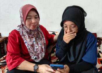 ERNIE Natasya Emizal,18, (kanan) tidak dapat menahan sebak menunjukkan keputusan 8A SPM kepada ibunya, Rozaida Zainol, di Guar Nangka, Perlis kelmarin.-UTUSAN