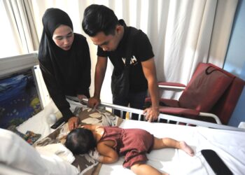 Nor Shahdan Rabu dan isteri, Nuranirah Rahmat menjaga Nur Anggun Seroja yang dirawat di hospital swasta akibat penyakit sawan   di Johor Bahru, semalam. – UTUSAN/RAJA JAAFAR ALI