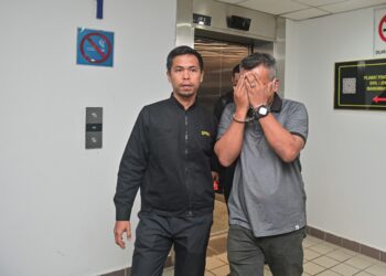 MOHD. Hisham Daud (kanan) didakwa atas empat pertuduhan membuat tuntutan  palsu 
dibawa keluar dari Mahkamah Sesyen Kuala Terengganu, hari ini. - UTUSAN/PUQTRA HAIRRY ROSLI