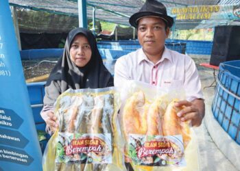 ZAILIYAH Adzri dan suami, Mohd. 
Khalilullah Che Mood bersama 
produk ikan air tawar keluarannya 
yang diternak dengan menggunakan 
pembiayaan daripada Amanah 
Ikhtiar Malaysia (AIM).