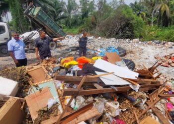 J. ARUL Kumar (kiri) dan Hazahar (tengah) melihat pelbagai sisa yang dibuang di kawasan tempat pembuangan sampah haram yang ditemukan di Kampung Jimah Lama, Port Dickson hari ini.-UTUSAN/MOHD. SHAHJEHAN MAAMIN.