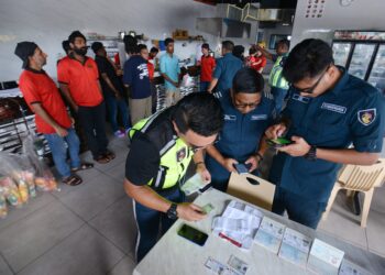 PEGAWAI Penguatkuasa MBS menjalankan pemeriksaan dalam serbuan yang dilakukan bersama JIM Negeri Sembilan di sebuah premis restoran di Taman Bukit Blossom, Seremban, semalam.-UTUSAN/MOHD. SHAHJEHAN MAAMIN.