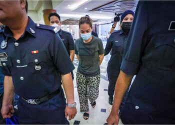 Murni Azlina Yurdeksi dibawa ke Mahkamah Sesyen Kuala Lumpur bagi menghadapi 58 pertuduhan menggunakan cek palsu berjumlah lebih RM2 juta milik Kesatuan Ragbi Malaysia (KRM). - UTUSAN/IQBAL ROSLI