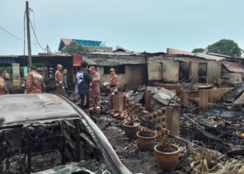 ANGGOTA Unit Forensik Bomba melakukan siasatan di lokasi kebakaran tiga buah rumah di Kampung Lundang, Kota Bharu, Kelantan. 
– UTUSAN/ROHANA MOHD. NAWI