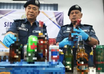 WAN Jamal Abdul Salam Wan Long (kiri) memeriksa minuman keras yang dirampas semasa sidang media di Rantau Panjang, Kelantan hari ini-UTUSAN/ROHANA ISMAIL