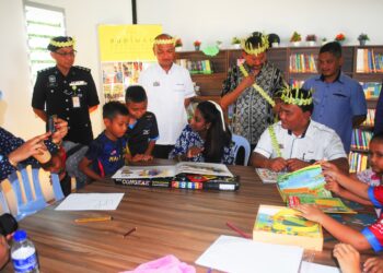 RAHMAD Mariman (kanan) bersama Anne Rajasaikaran (tengah) menyantuni anak-anak orang asli pada pembukaan Perpustakaan Kanak-kanak Kampung Orang Asli Gapam Baru di Dewan Komuniti Kampung Orang Asli Gapam Baru, Asahan, Melaka. - UTUSAN/AMRAN MULUP