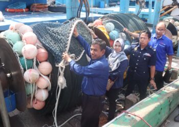 WAN Muhammad Aznan Abdullah (depan) ketika memeriksa vesel pukat tunda serta peralatan menangkap ikan yang dirampas dalam Ops Rentas semasa satu sidang akhbar di Batu Maung, Pulau Pinang.-UTUSAN/IQBAL HAMDAN