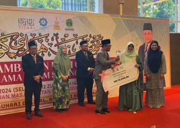 AMIRUDIN Shari menyampaikan anugerah Tokoh Guru Perempuan 2024 kepada Mariani Toilan dalam Majlis Sambutan Hari Guru JAIS 2024 di Shah Alam, Selangor, semalam. - UTUSAN / ABDUL RAZAK IDRIS