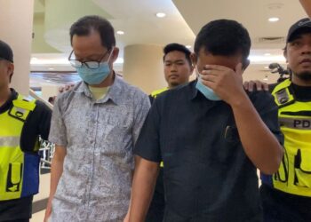 Chin Khiam Kong (kiri) dan Suhairon Abdullah dibawa anggota polis ke Mahkamah Sesyen Kuala Lumpur bagi menghadapi pertuduhan rasuah RM1.25 juta. UTUSAN/NORLIZAH ABAS