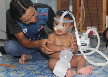 MOHD Azlan Ishak bersama Mohd. Aariz Zafran yang menghidap paru-paru kronik, gerd dan saiz limpa yang besar memerlukan alat bantuan pernafasan untuk tempoh 24 jam ketika ditemui di Kuala Kedah, Alor Setar.