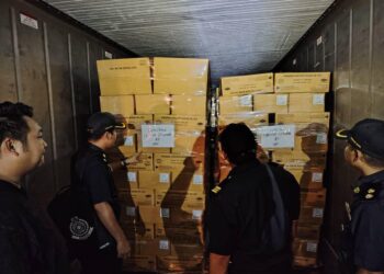 PEGAWAI KDPN Sabah memeriksa kotak ayam sejuk beku yang disita semasa pemeriksaan di sebuah stor di Inanam, Kota Kinabalu semalam-IHSAN KPDN
