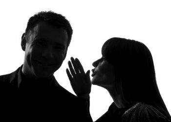 one  couple man and woman whispering at ear in studio silhouette isolated on white background