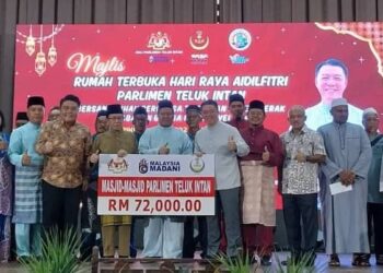 NGA Kor Ming (depan, tengah) menyerahkan peruntukan untuk masjid Parlimen Teluk Intan pada Majlis Madani Muhibah Aidilfitri di Teluk Intan hari ini. - UTUSAN/AIN SAFRE BIDIN