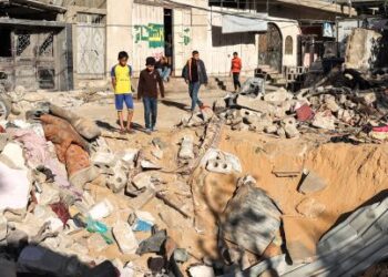 BEBERAPA orang remaja lelaki Palestin melihat lubang berbentuk kawah hasil letupan bom yang dilancarkan tentera Israel yang meranapkan bangunan dan kediaman penduduk di Rafah, selatan Gaza.  – AFP