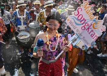 ORANG ramai mengambil bahagian dalam perarakan besar-besaran pada malam Songkran atau Tahun Baharu Thai, di Jalan Khao San di Bangkok pada 12 April 2024. -AFP