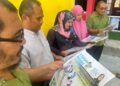 SEBAHAGIAN ibu bapa membaca paparan sisipan Utusan Pelajar ketika menunggu kepulangan anak masing-masing di pekarangan Sekolah Kebangsaan (SK) Cherang Ruku, Pasir Puteh, Kelantan, semalam. 
– UTUSAN/TOREK SULONG