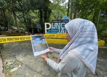 SEORANG pengunjung membaca notis penutupan sementara TER Puncak Janing yang disebabkan penyakit kencing tikus di Padang Terap. -UTUSAN/SHAHIR NOORDIN