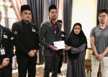 MOHAMAD Rosli Mustapai (tiga dari kiri) menyampaikan sumbangan kepada Noraini Mat Sari pada program Ziarah Waris Jemaah Haji di Kampung Keseng, Kuala Besar Kota Bharu semalam. – UTUSAN/ ROSLIZA MOHAMED