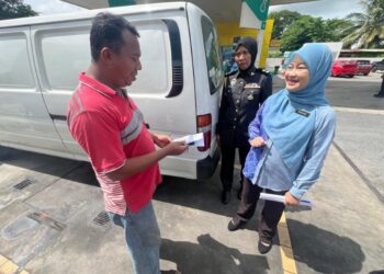 NORAZAH Jaapar (kanan) memberikan advokasi berhubung inisiatif Budi Madani di sebuah stesen minyak sekitar Padang Besar, Perlis. -UTUSAN/ASYRAF MUHAMMAD