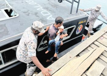 ANGGOTA Maritim Zon Kudat membantu memindahkan pesakit dari Klinik Kesihatan Karakit, Pulau Banggi, Kudat, Sabah. – IHSAN MARITIM