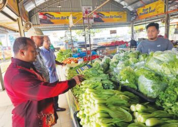 MOHAMAD Fadlee Hassan (kiri) meninjau bekalan sayuran-sayuran di Pasar Tani Kekal di Chendering, Kuala Terengganu, semalam. – UTUSAN/ZAID MOHD. NOOR