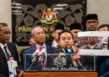 Wan Saiful Wan Jan menunjukkan bukti bergambar  perjumpaan beliau dengan seseorang dalam  cubaan membeli sokongan pada sidang akhbar di bangunan Parlimen semalam.