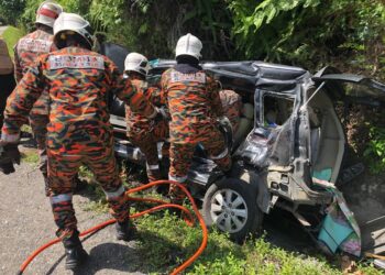 ANGGOTA bomba mengeluarkan mangsa dalam kenderaan yang terlibat kemalangan di Jalan Simpang Pulai-Cameron Highlands, Ipoh hari ini.- U UTUSAN/IHSAN JBPM