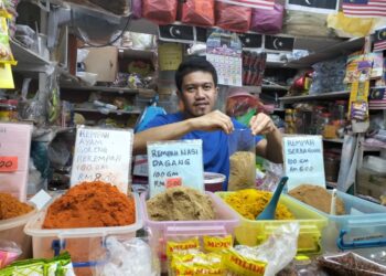 MUHAMMAD Shahrulnizam Rasman menunjukkan sebahagian rempah-ratus yang dijual di premisnya di Pasar Kedai Payang, Kuala Terengganu, kelmarin. – UTUSAN/KAMALIZA KAMARUDDIN