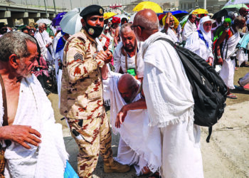 A man affected by the scorching heat is helped by another Muslim pilgrim and police officer the site of the symbolic 'stoning of the devil' ritual during the annual hajj pilgrimage in Mina on June 16, 2024. The death toll from this year's hajj has exceeded 1,000, an AFP tally said on June 20, 2024, more than half of them unregistered worshippers who performed the pilgrimage in extreme heat in Saudi Arabia. All told, around 10 countries have reported 1,081 deaths during the annual pilgrimage, one of the five pillars of Islam which all Muslims with the means must complete at least once. (Photo by FADEL SENNA / AFP)