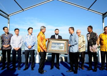 TUNKU Ismail Sultan Ibrahim menyaksikan penyerahan  cenderamata oleh Onn Hafiz Ghazi kepada Dr. Vivian Balakrishnan  di tengah tambak  sempadan Johor dan Singapura  sempena Ulangtahun ke 100 tahun Tambak Johor di, Johor Bahru hari ini. - UTUSAN/RAJA JAAFAR ALI