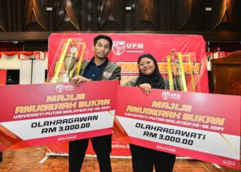 Ruslem Zikry Putra dan Nani Sahirah Maryata menunjukkan trofi anugerah olahragawan dan olahragawati yang diraih pada Majlis Anugerah Sukan Universiti Putra Malaysia Ke-38 di Serdang. - UTUSAN/SYAKIR RADIN