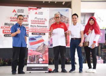 JOACHIM Gunsalam (kiri) bersama Tengku Ahmad Badli Shah Raja Hussin (tiga kanan) pada majlis pelancaran Program Komuniti Cashless di Pentas Budaya, Kundasang baru-baru ini.