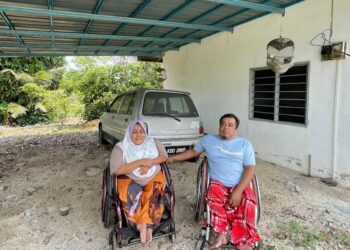 Che Fauzi Abdullah dan Noor Azizah Zainol bergambar di hadapan bengkel mereka yang terbengkalai kerana kekurangan modal.