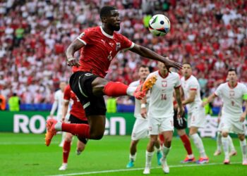 PEMAIN pertahanan Austria, Kevin Danso mengeluarkan bola dari kawasan bahaya dalam aksi menentang Poland pagi ini. - AFP