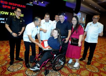 AZNAN Tamin menyampaikan Anugerah Inspirasi kepada How Xue Qi yang cacat anggota badan dalam Majlis Anugerah Kecemerlangan SPM 2023 di Hotel KSL Resort, Johor Bahru, semalam. -UTUSAN/RAJA JAAFAR ALI