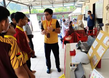 Mahasiswa UTM menerangkan kepada pelajar Kolej Vokasional Juasseh tentang bidang kemahiran yang ditawarkan di UTM dalam Program Siswa Noghori Turun Padang di Masjid Kariah Kampung Terusan, Kuala Pilah semalam.-UTUSAN/NOR AINNA HAMZAH