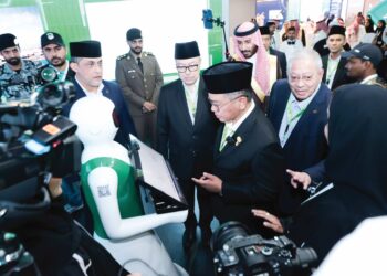 MOHD Na'im Mokhtar (tengah) melihat robot pintar ketika melawat salah satu ruangan pameran sempena penganjuran Simposium Utama Haji Ke-48 di Mekah, semalam.