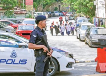 ANGGOTA polis mengawal ketat laluan masuk ke Apartmen Idaman, Damansara Damai, Selangor, semalam. 
– UTUSAN/M FIRDAUS M JOHARI