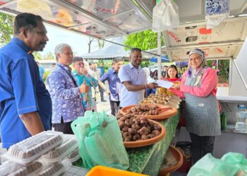 J. ARUL Kumar Bersama Setiausaha Majlis Bandaraya Seremban (MBS), Mas Midyawan Yahya memberikan surat tawaran MyKiosk kepada peniaga-peniaga di  Nilai, Seremban baru-baru ini.