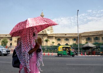 SEORANG wanita menggunakan payung bagi melindungi dirinya dari cuaca panas melampau di New Delhi.- AGENSI