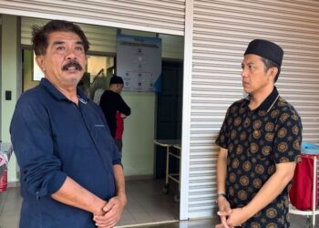 SAIFULLIZAN Abu (kanan) ketika ditenangkan oleh Ahli Dewan Undangan Negeri (ADUN) Bukit Ibam, Nazri Ahmad (kiri) yang turut hadir menziarahi mangsa. - FOTO/NORHAFIZAN ZULKIFLI