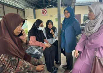 SITI Zulaikha Hamzah (dua dari kiri) ketika ditenangkan ahli keluarga dan rakan sekerja ayahnya di Unit Forensik HTAA, Kuantan. - FOTO/NORHAFIZAN ZULKIFLI