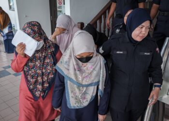 KESEMUA tertuduh diiringi anggota polis selepas didakwa di Mahkamah Sesyen, Ayer Keroh, Melaka atas pertuduhan mengabaikan dua beradik, sejak Mac lalu. - UTUSAN/SYAFEEQ AHMAD