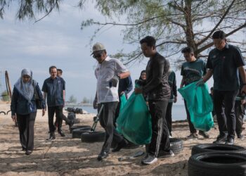 NIK NAZMI Nazmi Nik Ahmad (hadapan, tengah) bersama pelajar mengutip sampah di pantai dalam program Jelajah Kelestarian Alam Santuni Golongan Belia di UMT, Kuala Nerus, hari ini. - UTUSAN/PUQTRA HAIRRY ROSLI