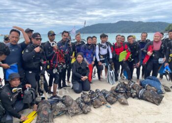 SEBAHAGIAN daripada penyelam yang menyertai program DAD bergambar bersama sampah sarap yang dikutip di dasar laut di perairan Pulau Perhentian, di sini, hari ini.