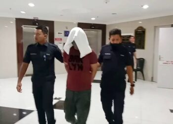 MOHD. Aduka Muhamad (tengah) yang didapati bersalah mengedar dadah dibawa keluar dari Mahkamah Tinggi Kuala Terengganu, hari ini. - UTUSAN/TENGKU DANISH BAHRI TENGKU YUSOFF